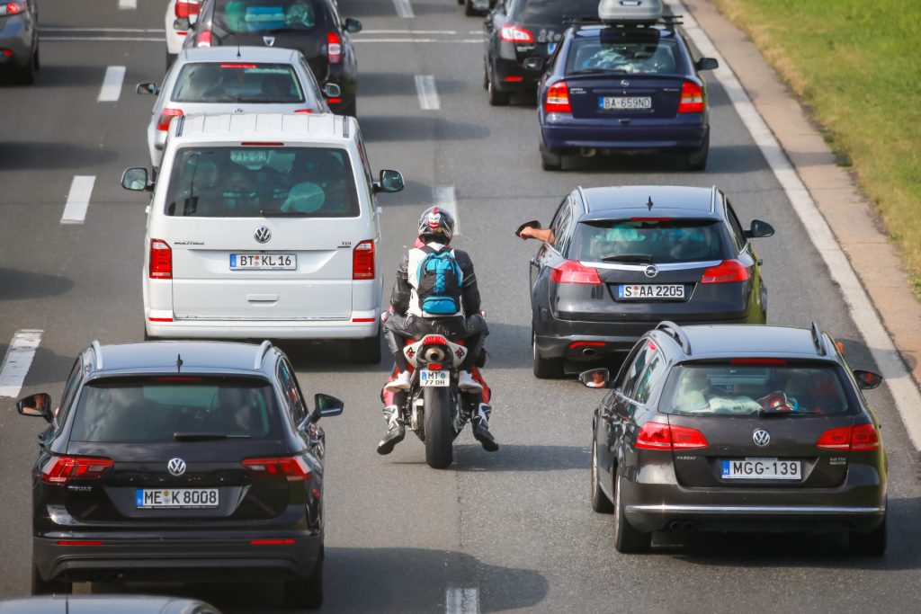 Motorcyclist driving between the lanes on a busy highway