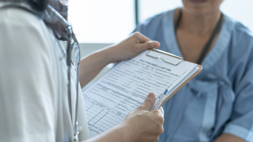 Doctor and patient reviewing medical claim form